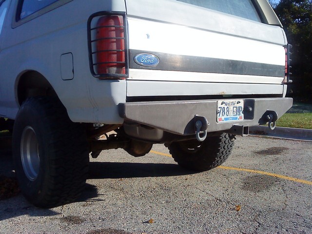 Lifted white SUV with fabricated steel rear bumper and taillight guards