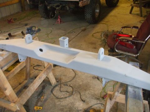 1995 Ford Bronco - A custom bumper is prepped for installation in a workshop, with a vehicle visible in the background.