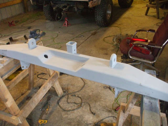 Custom bumper on sawhorses, with a vehicle in the background