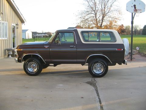 1978 Ford Bronco - Side view of a 1978 Ford Bronco with a two-tone paint scheme and spare tire on the back.