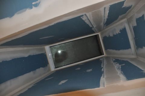 1996 Ford Bronco - The interior of a room shows unfinished drywall and blue walls, with a skylight overhead.