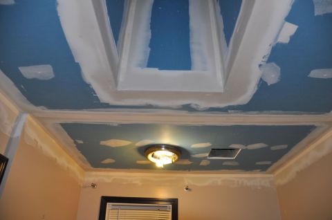 1996 Ford Bronco - A ceiling undergoing renovation, showing areas of drywall mud and blue primer, with a central light fixture.