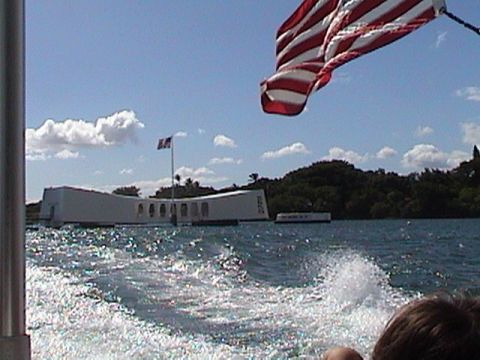 1971 Ford Ranchero - A boat travels through the water, leaving a wake, with the USS Arizona Memorial and an American flag visible under a blue sky.