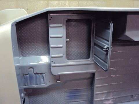 1948 Jeep Wrangler - The interior of a vehicle shows diamond plate paneling and a storage compartment with its door ajar.