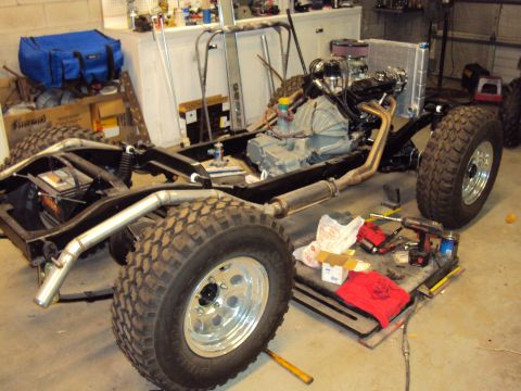 1948 Jeep Wrangler - Jeep CJ chassis undergoing engine and transmission installation in a garage workshop.