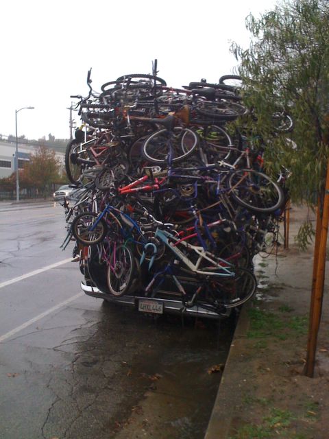 1968 Ford Mustang - Truck overloaded with bicycles, license plate LHYL446, parked on a wet street.