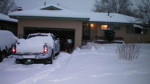 2003 Ford Taurus - A snow-covered 4x4 pickup with its taillights lit backs out of an open garage at a ranch house at dusk, its bed and tailgate buried under s…