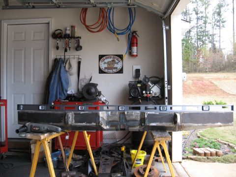 1995 Ford F-150 - A truck bumper is shown on sawhorses in a garage, with a level placed across its top.