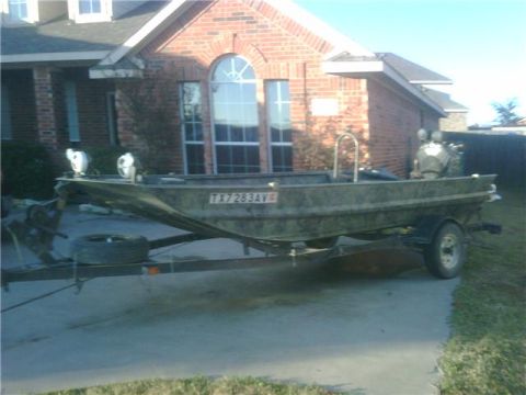 2006 Ford F-250 - A camouflaged boat is parked on a trailer in front of a brick house, with a Texas license plate visible.