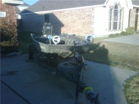 2006 Ford F-250 - A boat is parked on a trailer in front of a house.