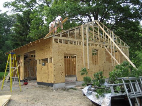 1996 Ford Bronco - Construction workers are building the frame of a house, with lumber and ladders visible on the site.