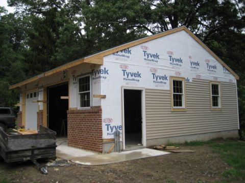 1996 Ford Bronco - Garage construction in progress, showing framing, Tyvek wrap, and siding installation.