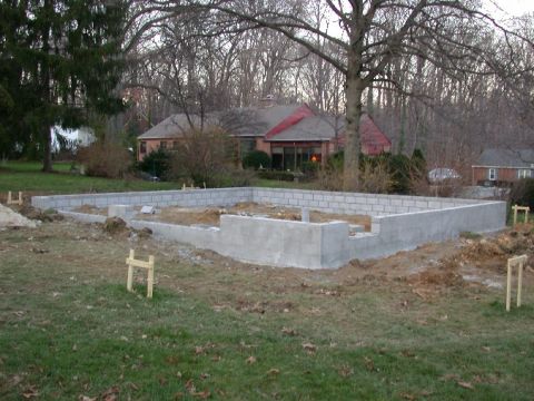 1996 Ford Bronco - A house foundation is under construction, with concrete blocks forming the walls on a grassy lot.