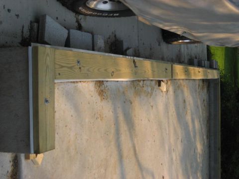 1996 Ford Bronco - A construction project involving wood framing is underway against a concrete wall, with a vehicle tire visible.