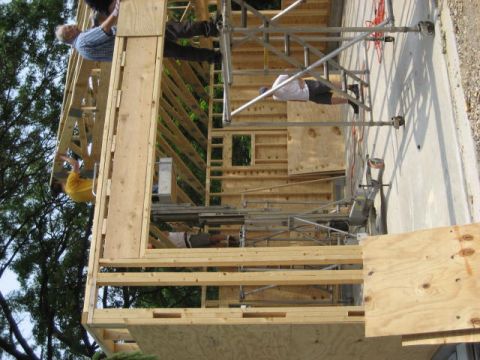 1996 Ford Bronco - Workers are seen on scaffolding around a building under construction, with framing and wooden materials visible.