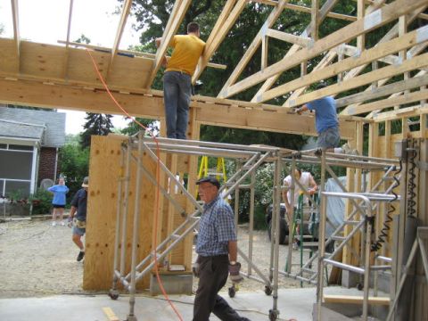 1996 Ford Bronco - Workers are actively engaged in building a wooden structure, with a house visible in the background.
