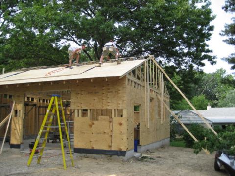 1996 Ford Bronco - Construction workers are seen on the roof of a building being built, with a ladder nearby.