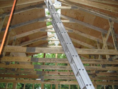 1996 Ford Bronco - Interior view of unfinished wooden roof structure with a ladder.