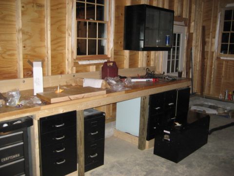 1996 Ford Bronco - A workshop scene a long workbench with various tools and storage cabinets underneath.