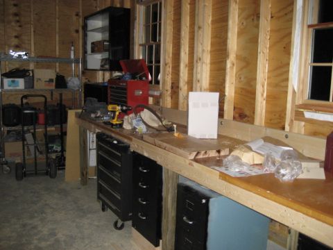 1996 Ford Bronco - A workshop scene a cluttered workbench with tools, storage drawers, and shelving units.