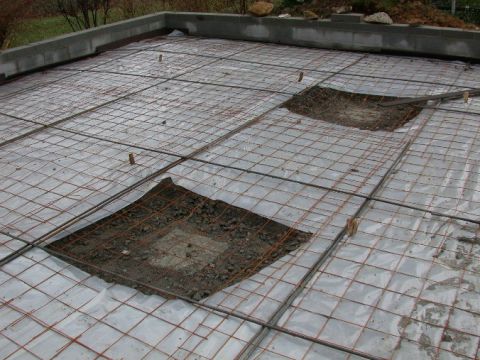 1996 Ford Bronco - A grid of steel rebar is laid over plastic sheeting on a concrete foundation, with two areas cleared to the dirt.