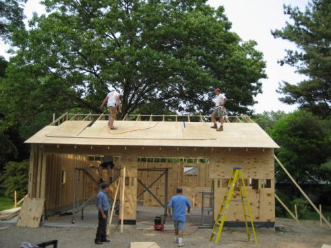 1996 Ford Bronco - Workers are constructing a building, with some on the roof and others on the ground near a ladder.