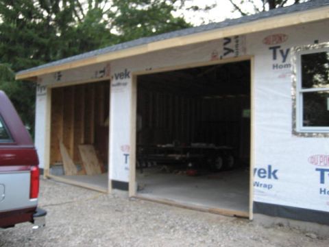 1996 Ford Bronco - A pickup truck is parked beside a garage that is being built.