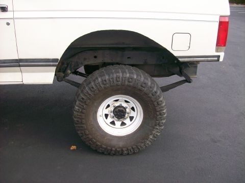 1989 Ford Bronco - Rear wheel and fender of a 1989 Ford Bronco, equipped with off-road tires.