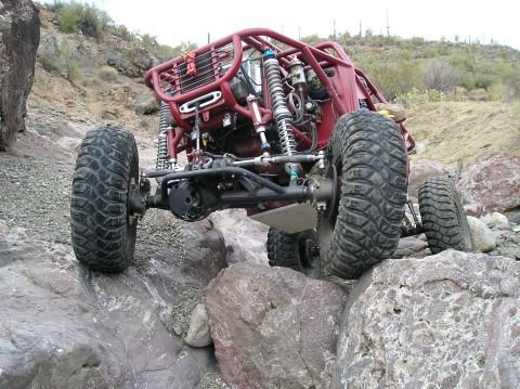 1986 Toyota Hilux - This heavily modified off-road buggy is shown tackling a challenging rocky trail.