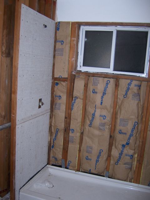 1991 Ford Bronco - A bathroom is under renovation, showing exposed framing, insulation, and a bathtub.