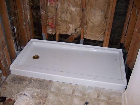 1991 Ford Bronco - A new white shower base is being installed in a bathroom under renovation, with exposed framing and insulation visible.