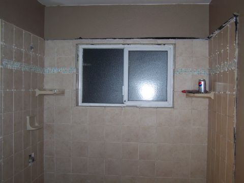 1991 Ford Bronco - A bathroom undergoing renovation, tiled walls, a sliding window, and a can of Pepsi on a shelf.