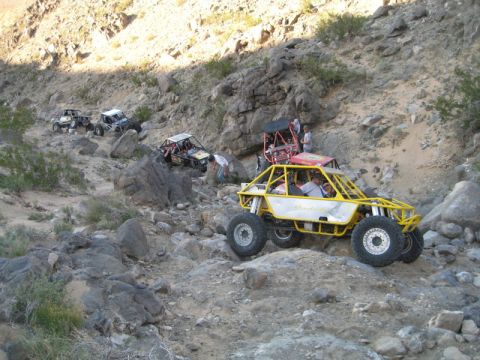 1992 Toyota Tacoma - Multiple custom off-road vehicles traverse a challenging rocky terrain.