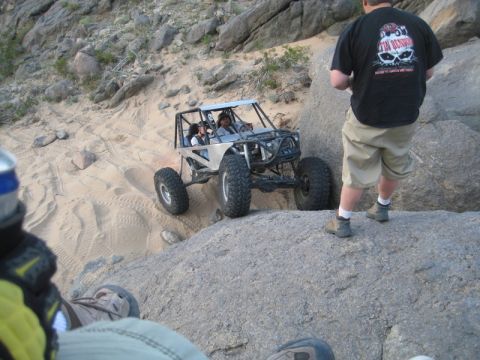 1992 Toyota Tacoma - An off-road buggy navigates a rocky and sandy trail with people inside.