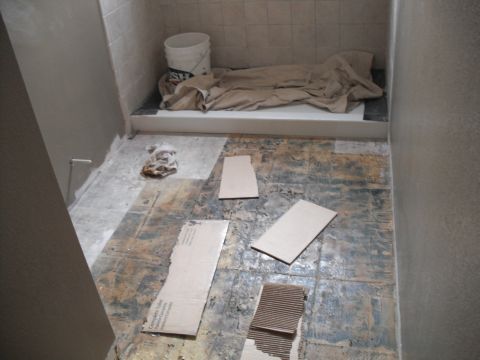 1991 Ford Bronco - The bathroom is undergoing renovation, with the old flooring stripped and materials staged for the next steps.