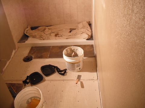 1991 Ford Bronco - Bathroom renovation underway, showing a bathtub, partially tiled floor, and construction supplies.