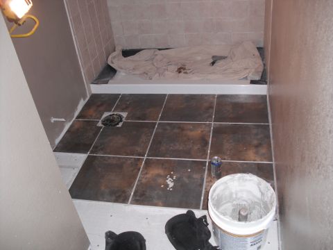 1991 Ford Bronco - Shower stall construction in progress, showing tiled floor and walls, and materials for installation.