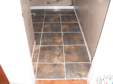 1991 Ford Bronco - A view down a hallway showing a recently tiled floor with dark brown and gray tiles.