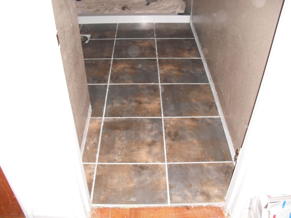 Tiled floor in a narrow hallway with brown and gray tiles