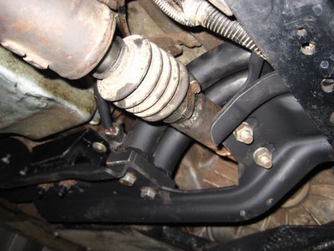 1989 Ford Bronco - Close-up view of vehicle undercarriage components, including exhaust and driveshaft parts.