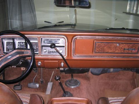 1978 Ford Bronco - The interior of a 1978 Ford Bronco displays its dashboard, steering wheel, and dual gear shifters.
