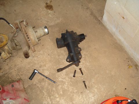 1991 Ford Bronco - A steering gear box and axle assembly are shown on the floor next to a socket wrench.