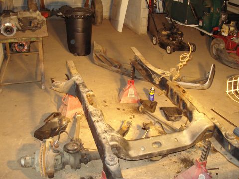 1991 Ford Bronco - Disassembled drivetrain and axles are laid out on the floor, suggesting a vehicle repair or restoration project.