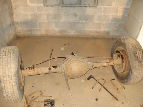 1991 Ford Bronco - A disassembled rear axle assembly rests on the floor, likely awaiting repair or replacement.