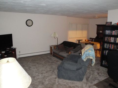 2000 Ford Crown Victoria - Interior view of a living room with furniture and a bookshelf filled with items.