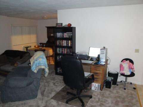 2000 Ford Crown Victoria - A view of a living space a desk with a computer, a bookshelf filled with media, and comfortable seating.