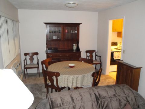 2000 Ford Crown Victoria - A dining room scene with a table set for a meal and a hutch against the wall.