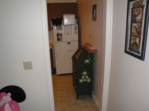 2000 Ford Crown Victoria - Interior view of an apartment hallway with a refrigerator and a decorative cabinet.