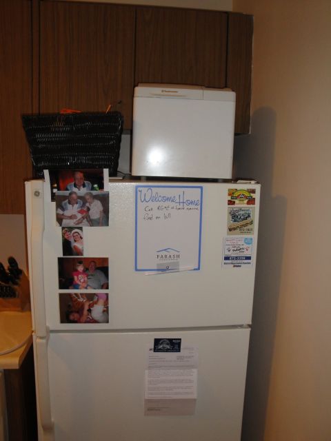 2000 Ford Crown Victoria - A refrigerator is adorned with family photos and a welcome note, with a bread maker placed on top.