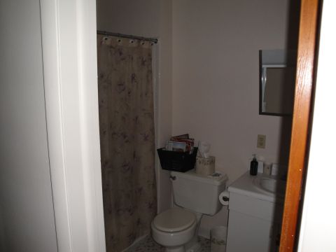 2000 Ford Crown Victoria - A view of a bathroom showing a toilet, sink, and a shower curtain with a floral pattern.